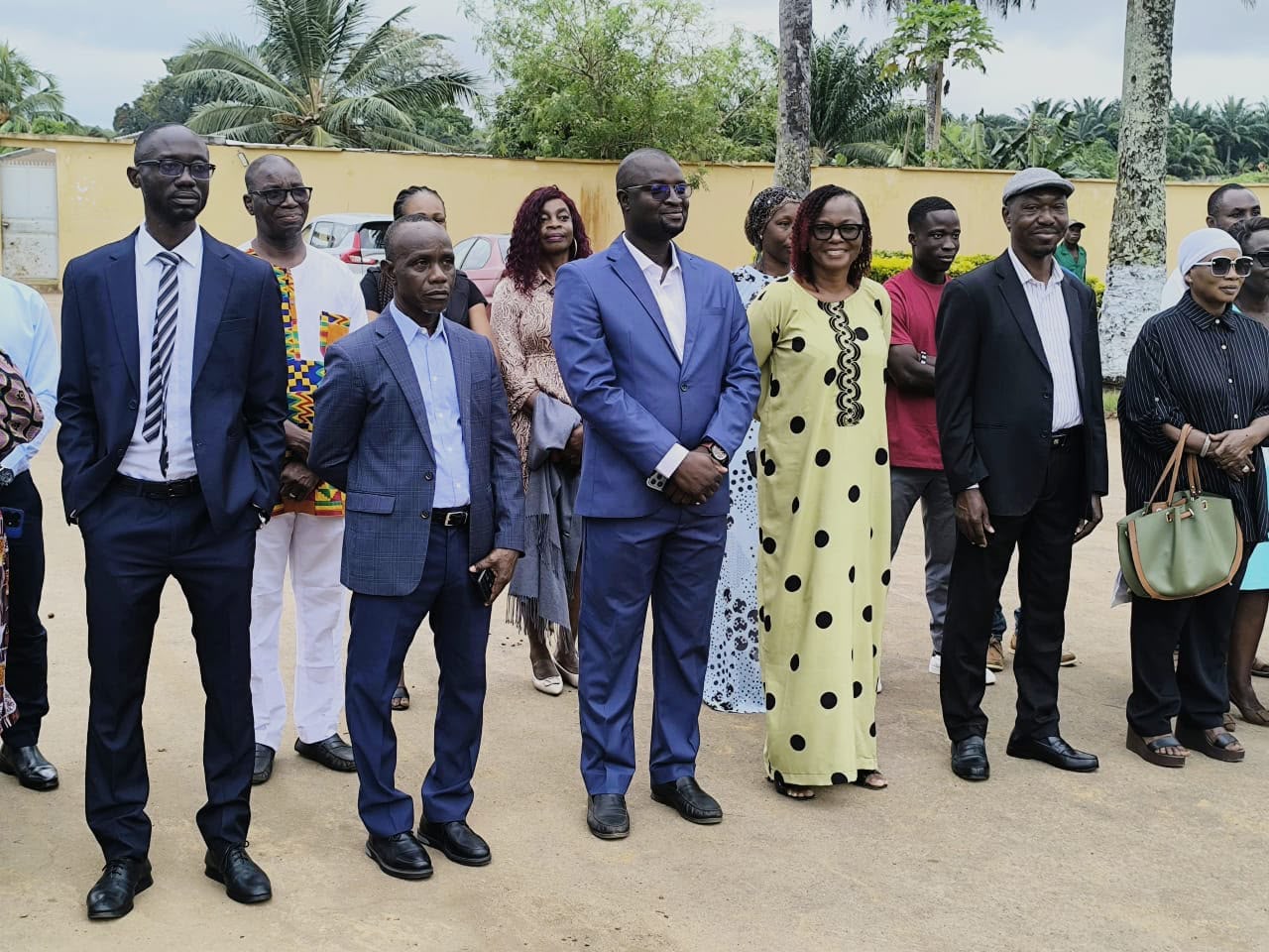 Photo de groupe du personnel de l'école, debout dans la cour